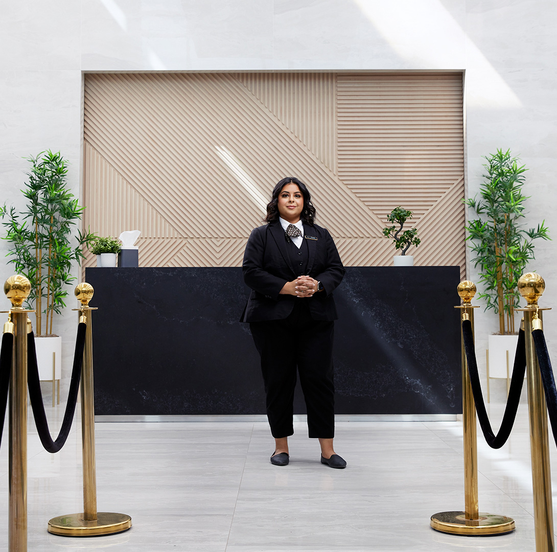Funeral Home Administrator standing in a funeral home reception area.